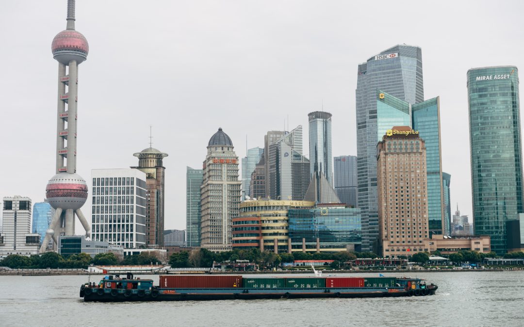 A barge with commercial goods floats on a river channel by downtown Shanghai.