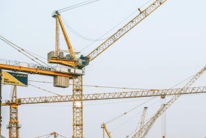 Cranes against a blank daytime sky, showing how digital design services from Pivotree help you build ecommerce websites.