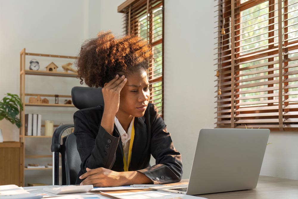 Frustrated business woman looking at her laptop