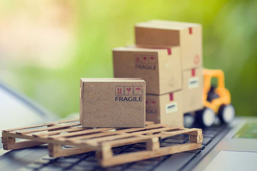 computer with shipping boxes and forklift on the keyboard